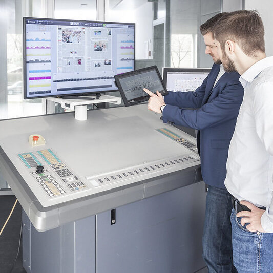 Two men looking at tablet screen printing equipment training